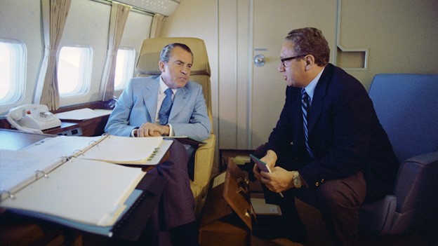 Președintele Nixon discută cu consilierul său pe probleme de securitate națională, Henry Kissinger, în drum spre China, 1972
