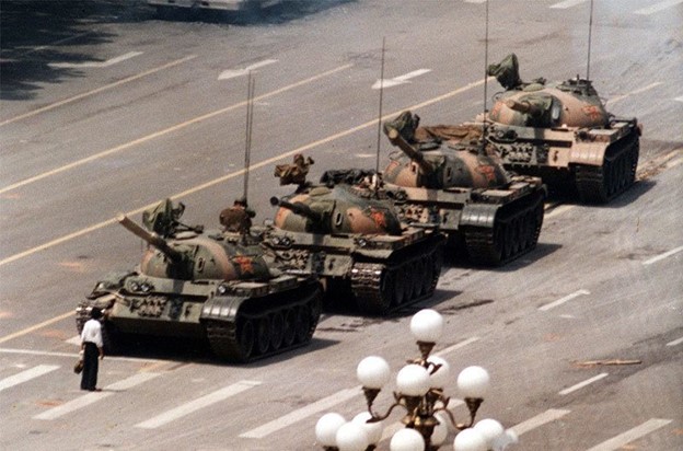 Renumitul "Tank Man" ( bărbatul în alb) înfruntă o coloană de tancuri în timpul protestelor din Piața Tiananmen